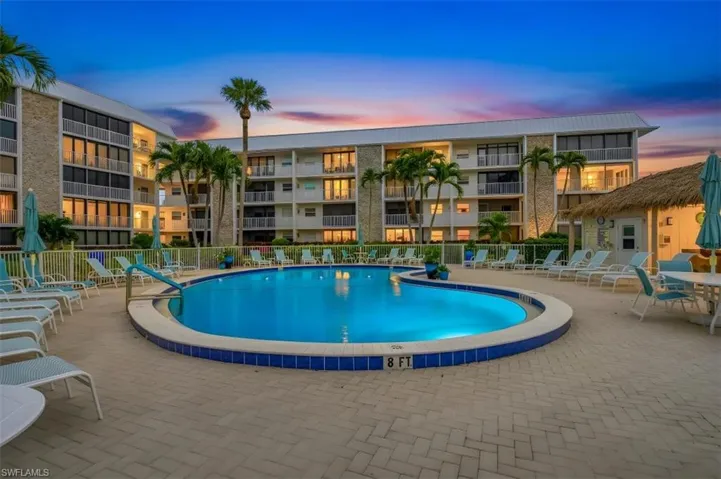 Pool at dusk with a community pool and a patio area