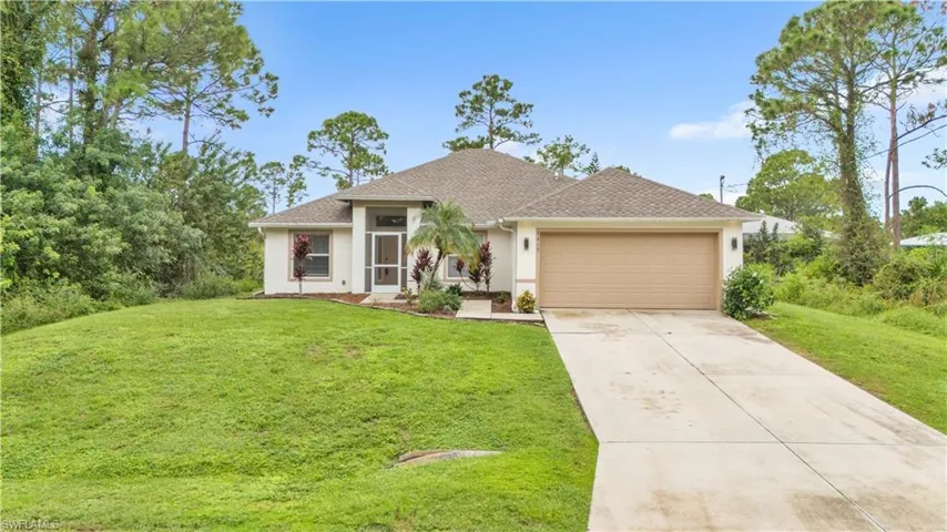View of front of home with a front yard and a garage