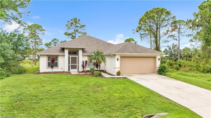 View of front of property with a garage and a front lawn
