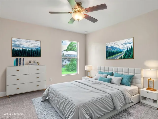 Carpeted bedroom featuring ceiling fan