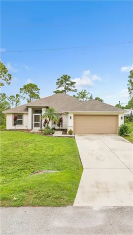 Single story home with a garage and a front yard