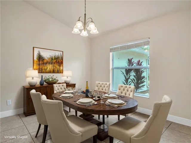 Tiled dining space featuring an inviting chandelier and lofted ceiling