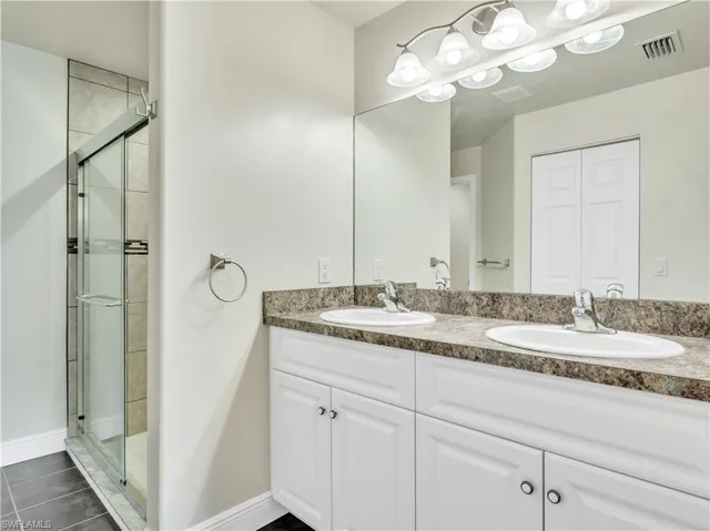 Bathroom featuring an enclosed shower, tile patterned floors, and vanity