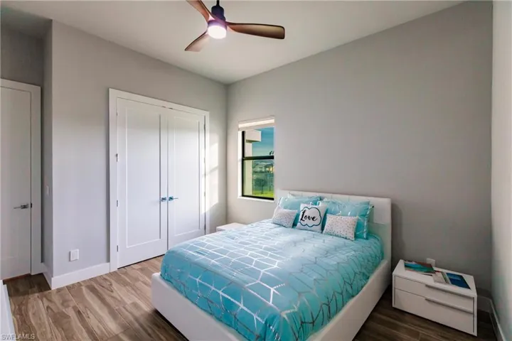 Bedroom with wood finished floors, a closet, and ceiling fan