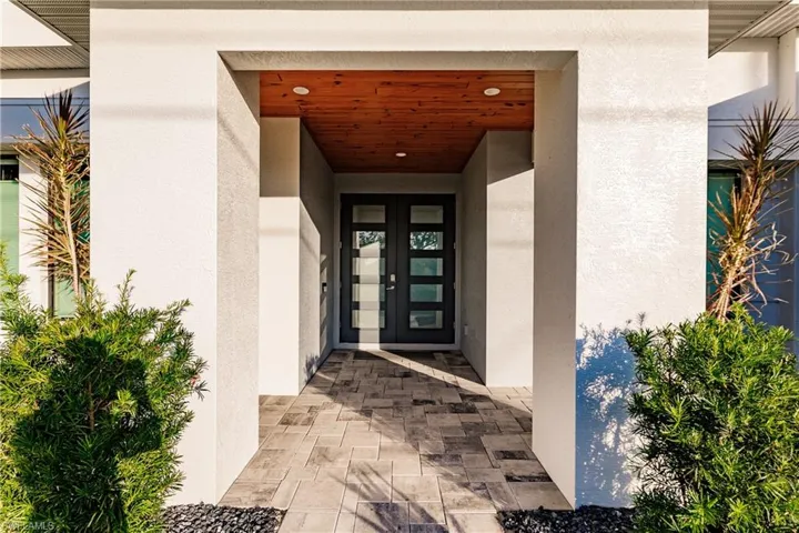 Doorway to property featuring french doors and stucco siding