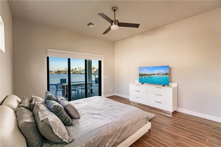 Bedroom featuring access to outside, wood finished floors, and a ceiling fan