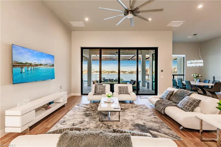 Living room featuring ceiling fan, wood finished floors, recessed lighting, and a chandelier