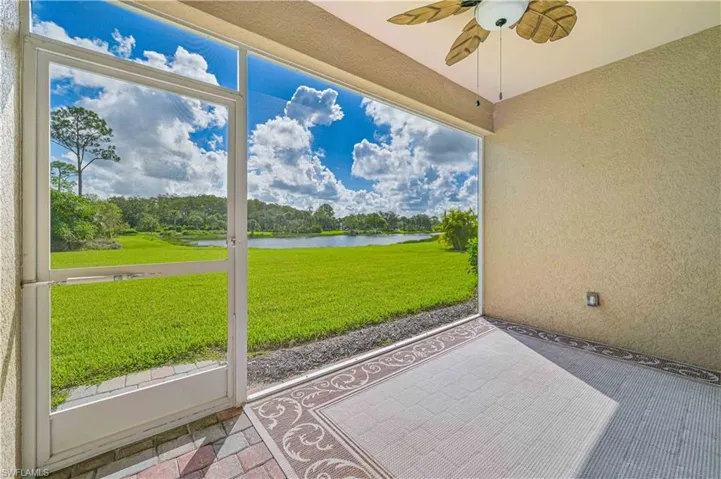 Sunroom / solarium with ceiling fan and a water view