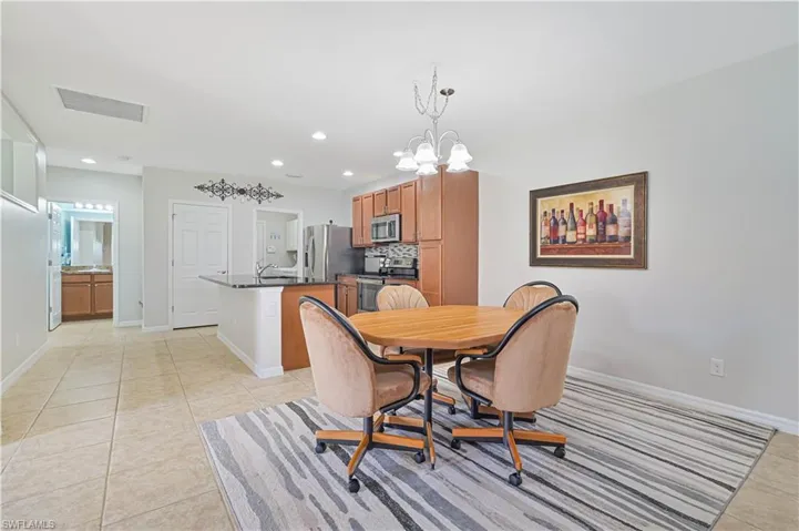 Dining room featuring light tile patterned floors, a chandelier, and sink