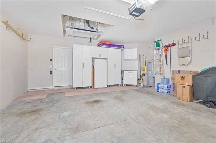 Garage featuring a garage door opener and water heater