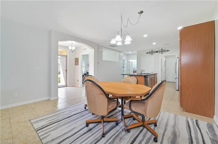 Tiled dining room featuring an inviting chandelier and sink