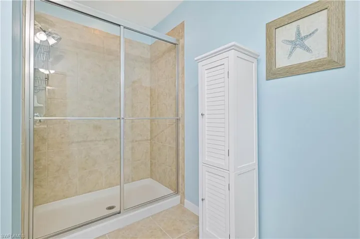 Bathroom featuring a shower with door and tile patterned floors