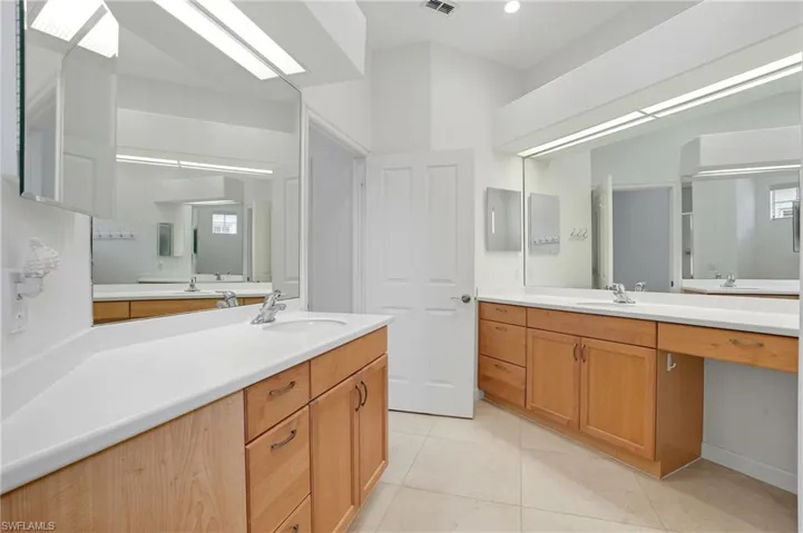 Bathroom with two vanities and light tile patterned floors