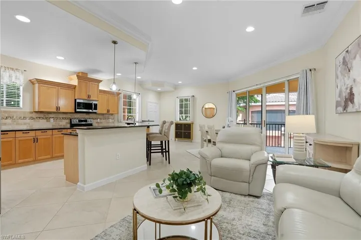 Living area featuring ornamental molding, light tile patterned floors, and recessed lighting