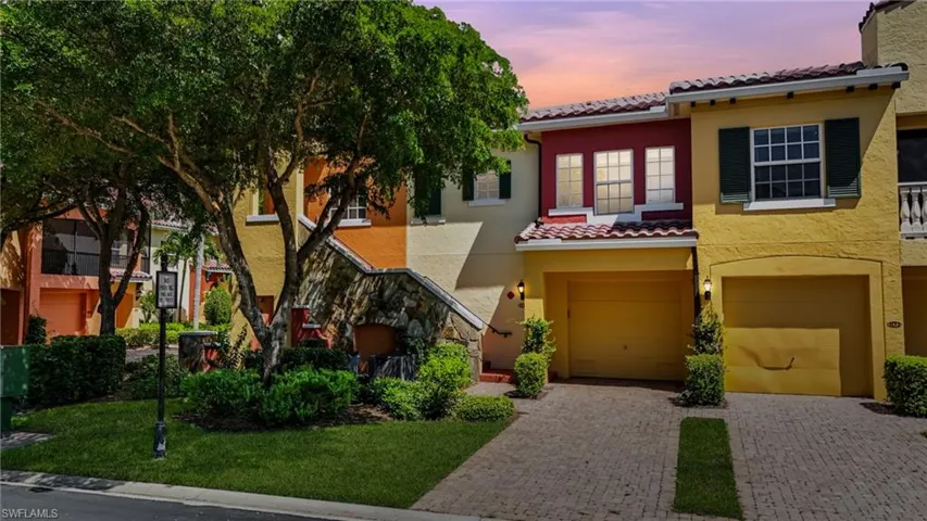 Mediterranean / spanish home with stucco siding, decorative driveway, a tiled roof, a garage, and a yard