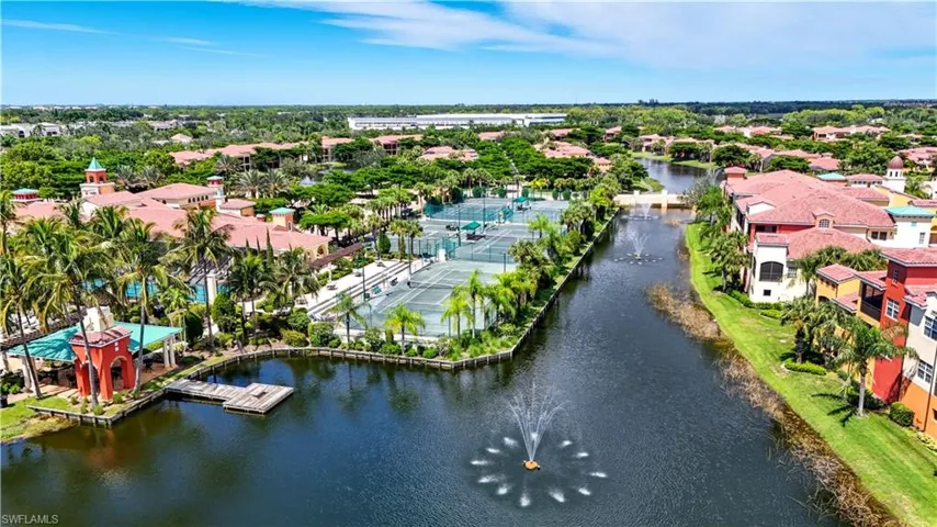 Aerial view of residential area with a nearby body of water and a tree filled landscape