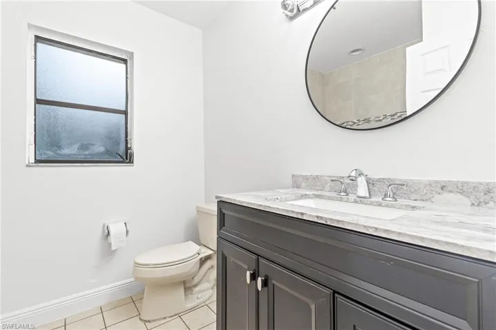 Bathroom with vanity, toilet, and tile patterned flooring
