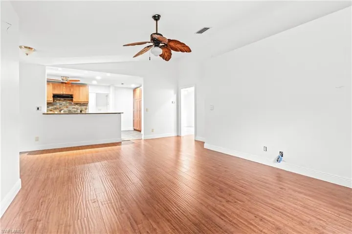 Unfurnished living room with light hardwood / wood-style floors, lofted ceiling, and ceiling fan