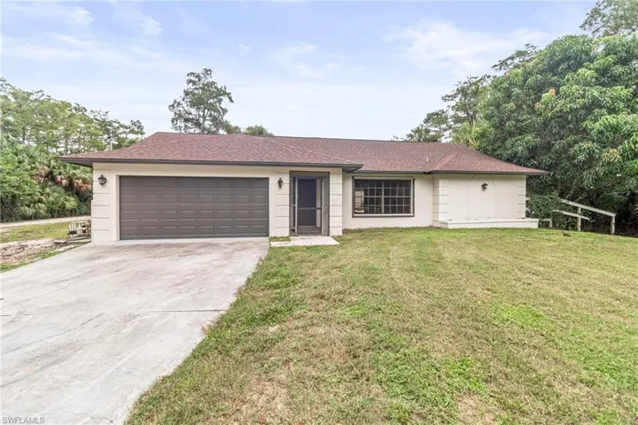 Ranch-style home featuring a garage and a front yard