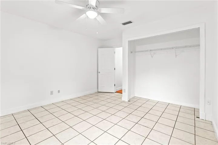 Unfurnished bedroom with light tile patterned flooring, a closet, and ceiling fan