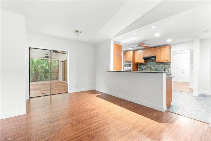 Kitchen with kitchen peninsula, ceiling fan, light hardwood / wood-style floors, and tasteful backsplash