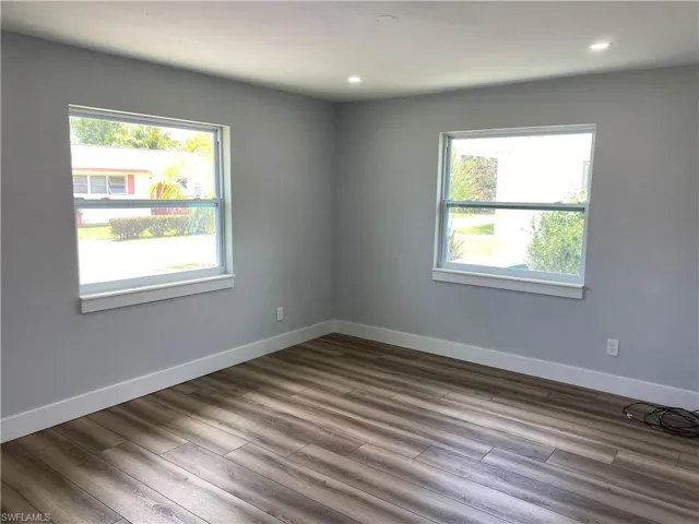 Spare room with wood finished floors, healthy amount of natural light, and recessed lighting