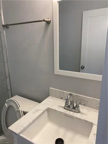 Bathroom featuring vanity and a textured wall