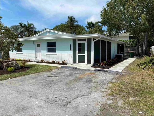 View of front facade featuring a sunroom and a front yard