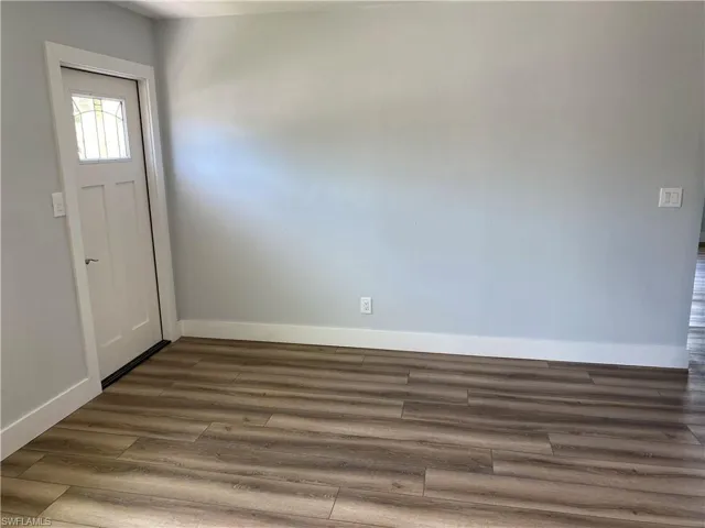 Entrance foyer with baseboards and dark wood-style flooring