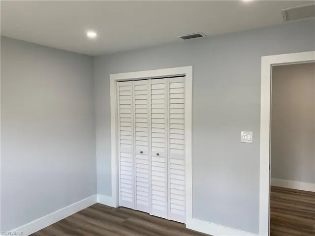 Unfurnished bedroom with dark wood-style floors, a closet, and recessed lighting