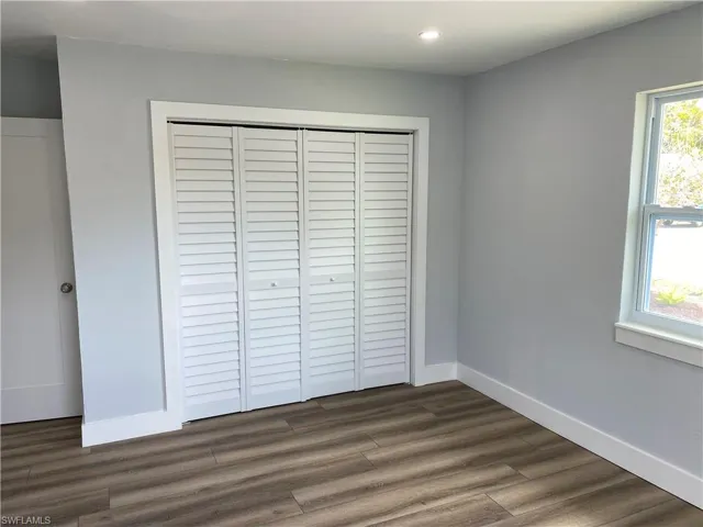 Unfurnished bedroom with a closet, dark wood-type flooring, and recessed lighting
