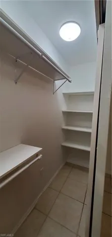 Master bedroom closet with light tile patterned floors