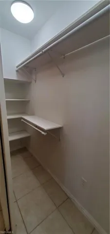 Master bedroom closet with light tile patterned floors