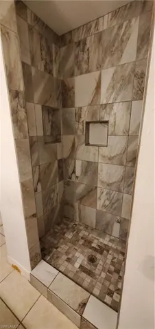 Master Bathroom with tiled shower and tile patterned flooring