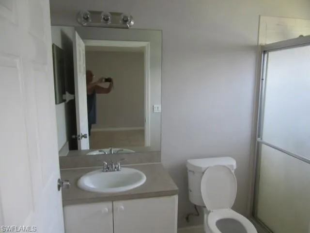 Vanity with an integrated sink, polished chrome faucet, and expansive wall-mounted mirror