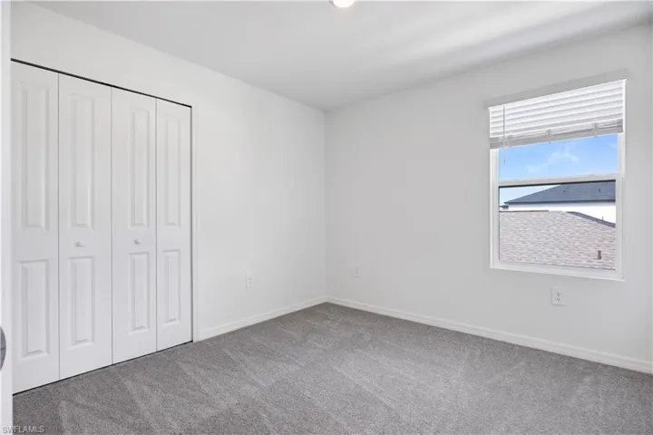 Room with neutral-toned walls and gray carpeting