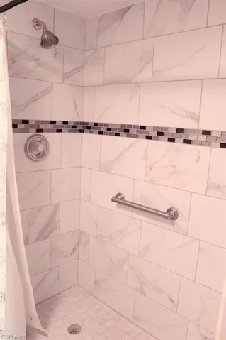 Full bath featuring a tile shower and a textured ceiling