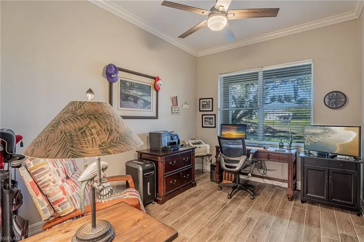 Office/Den with furniture, Fellows shredder, printers, cabinet, desk & chair, TV, cabinet, clock, porcelain floor, crown molding and fan.