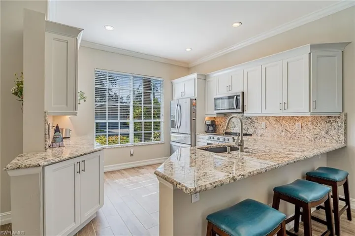 Entering the kitchen you see the windows with Granite, 36 inch Kraft Maid Cabinets with self closing drawers and doors, under the cabinets lighting, all Whirlpool appliances, Blanco sink, a soap dispenser and to the left a quiet disposal.