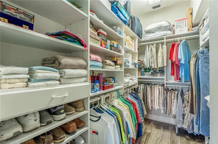 Master bedroom closet with built in cabinets.