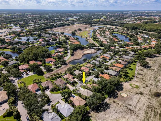 View of house with the arrow and working on the 12 hole of the private golf course.  Looking right over the arrow, you see a large lake with water in front of that hole,  That is a par 3 practice hole.