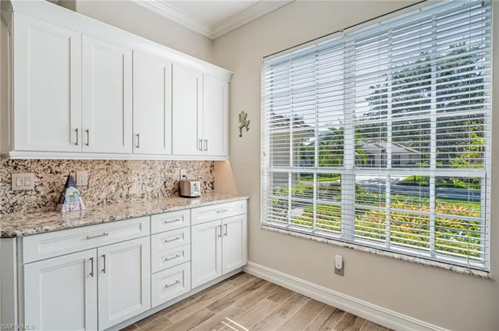 Same kitchen cabinets and window looking outside with Granite on window sills.