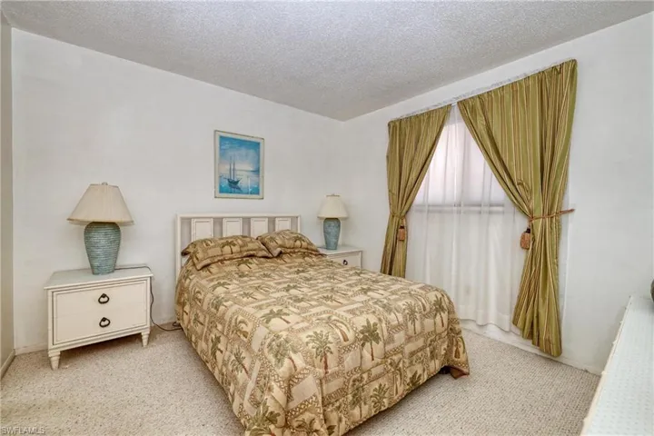 Bedroom featuring light colored carpet and a textured ceiling