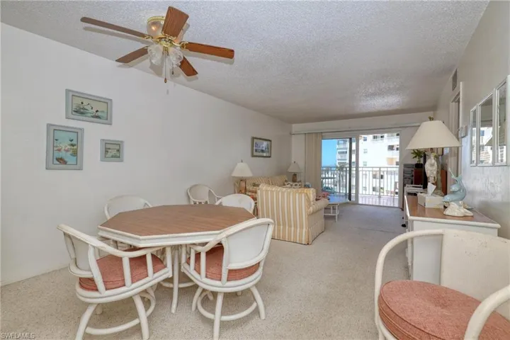 Dining room featuring a textured ceiling, light carpet, and ceiling fan