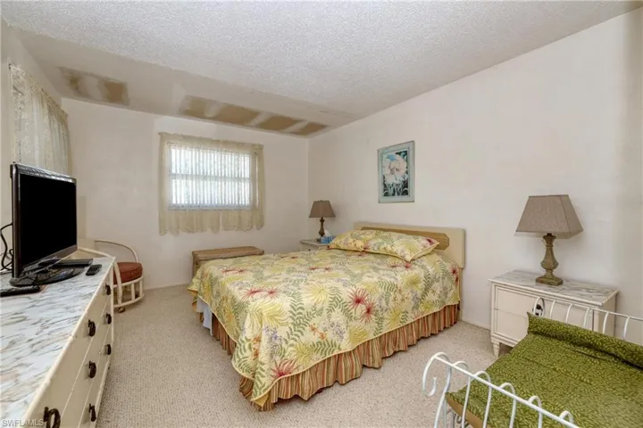 Bedroom featuring light carpet and a textured ceiling