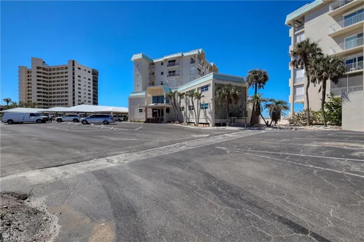 View of building exterior featuring uncovered parking
