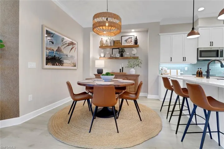 Dining room with light wood-type flooring, recessed lighting, and crown molding