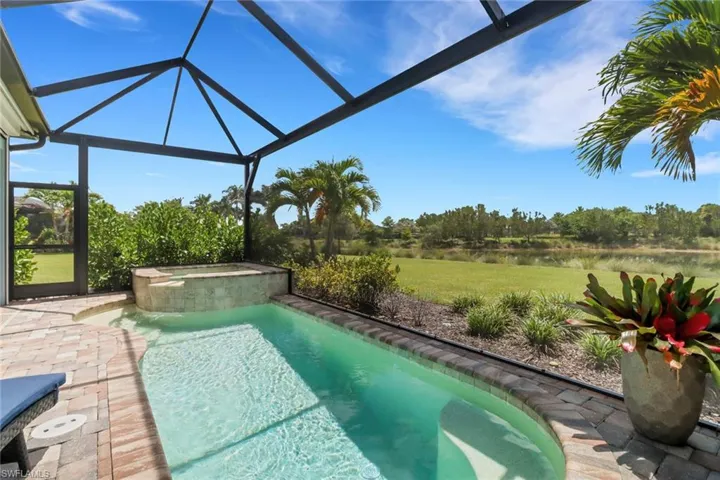 View of swimming pool with a patio, a sunroom, a water view, a lanai, and a lawn