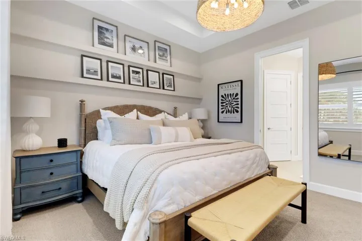 Bedroom featuring light colored carpet and a chandelier