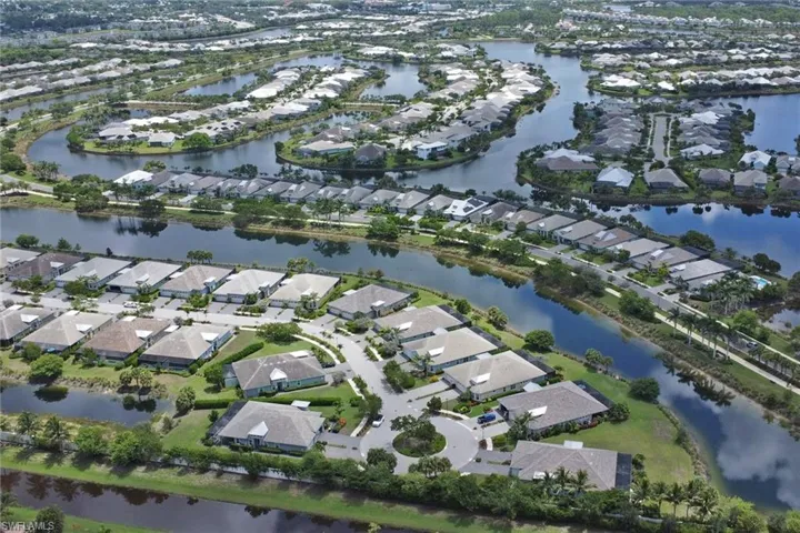 Aerial view of property's location with a nearby body of water and nearby suburban area